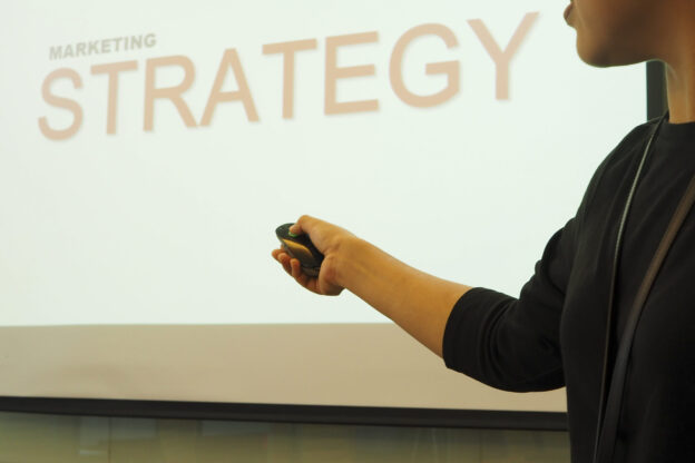 ビジネスマンがレーザーポインターを使いプレゼンテーションを行う様子