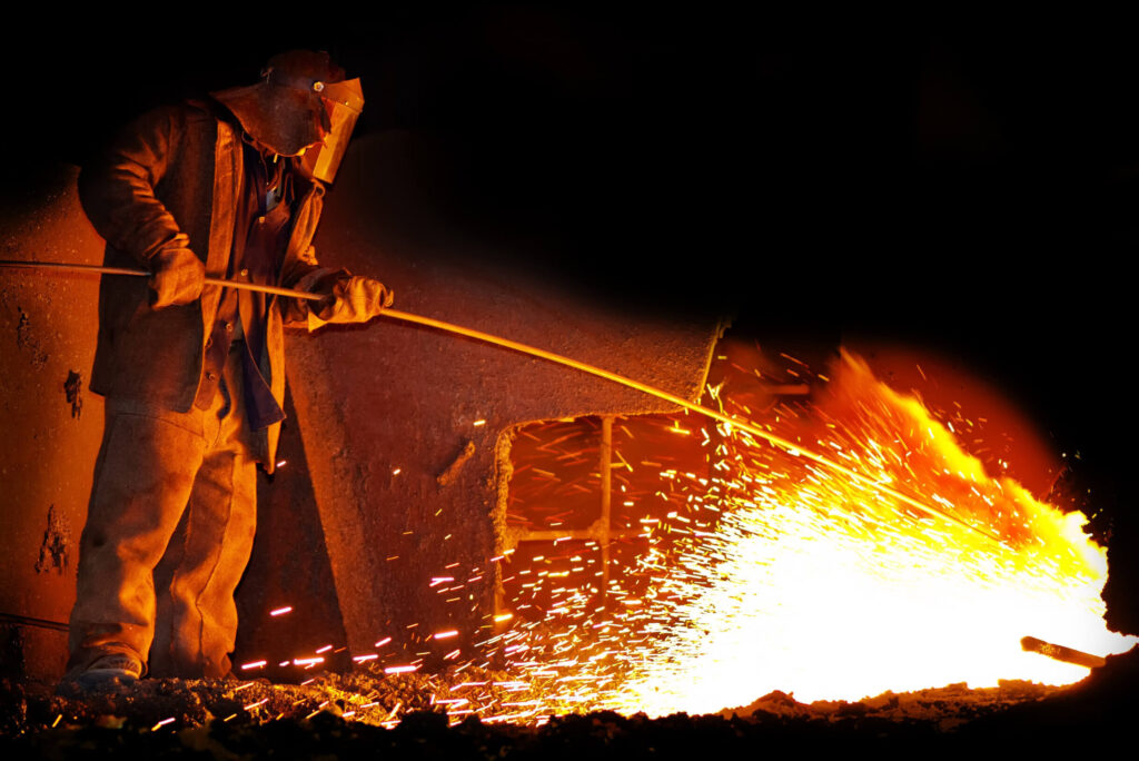 高温の溶解炉近くで危険な作業を行う様子