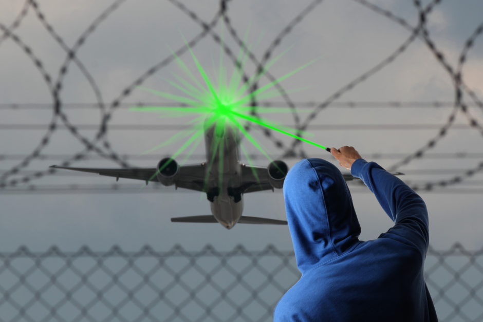 レーザーポインターを航空機に向け悪用している人物のシルエット