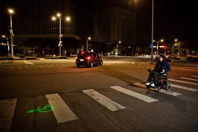 DOEで車椅子のシンボルマークを照射する注意喚起用グリーンレーザーポインターのイメージ